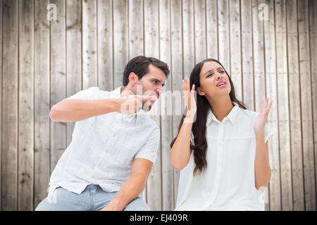 Composite image of couple sitting on chairs arguing Stock Photo