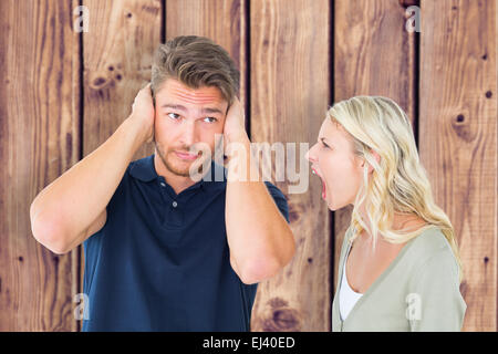 Composite image of man not listening to his shouting girlfriend Stock Photo