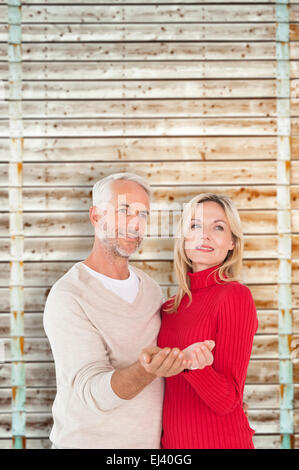 Composite image of happy couple holding their hands out Stock Photo