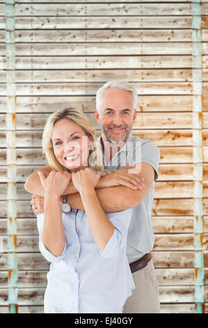 Composite image of happy couple standing and hugging Stock Photo