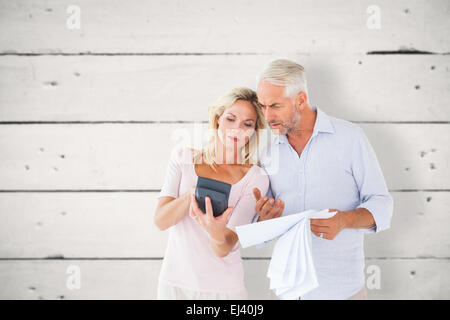 Composite image of anxious couple working out their bills Stock Photo