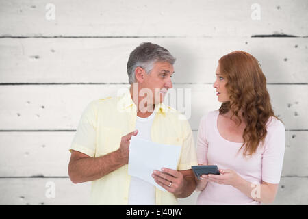 Composite image of casual couples working out their bills Stock Photo