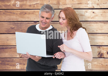 Composite image of casual couple using laptop together Stock Photo