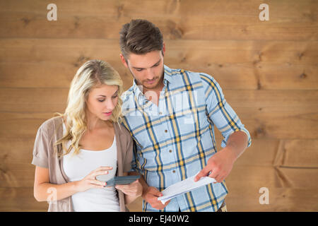 Composite image of attractive couple working out their finances Stock Photo