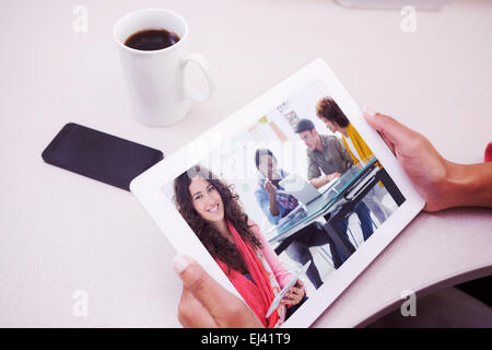 Composite image of smiling designer using tablet Stock Photo