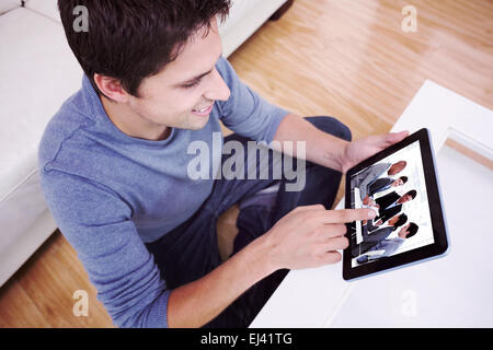 Composite image of overhead view of man using digital tablet in living room Stock Photo