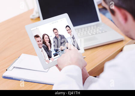 Composite image of doctors using laptop and digital tablet in meeting Stock Photo