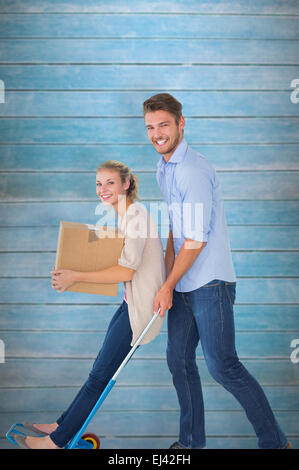 Composite image of young couple having fun on moving trolley Stock Photo