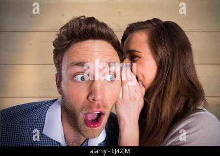 Composite image of woman whispering secret into friends ear Stock Photo