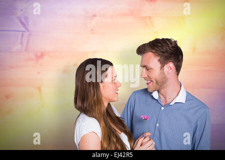 Composite image of man kissing woman as she holds flower Stock Photo