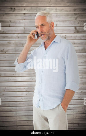 Composite image of serious man talking on the phone Stock Photo