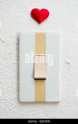 close up of white light switch with a red heart above Stock Photo
