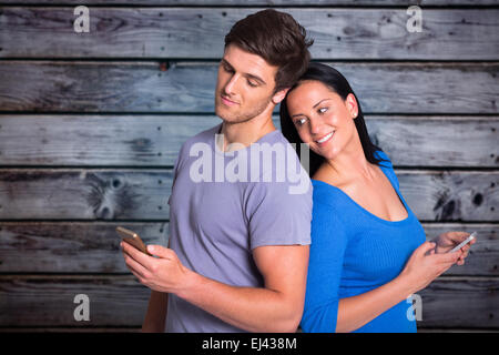 Composite image of young couple sending a text Stock Photo