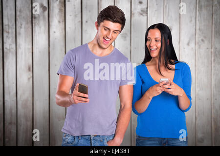 Composite image of young couple sending a text Stock Photo