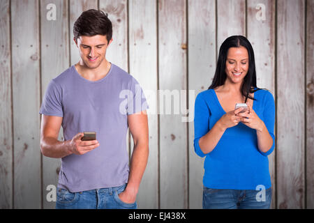 Composite image of young couple sending a text Stock Photo
