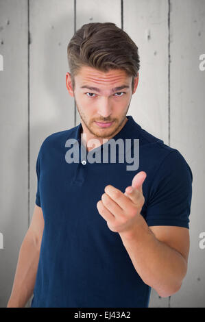 Composite image of handsome young man pointing at camera Stock Photo