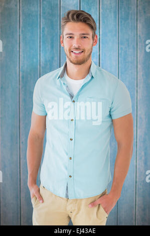 Composite image of handsome young man posing with hands in pockets Stock Photo