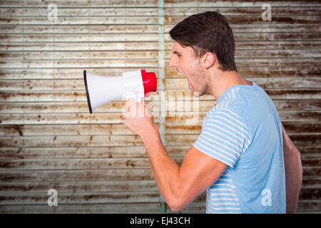 Composite image of young man shouting through megaphone Stock Photo