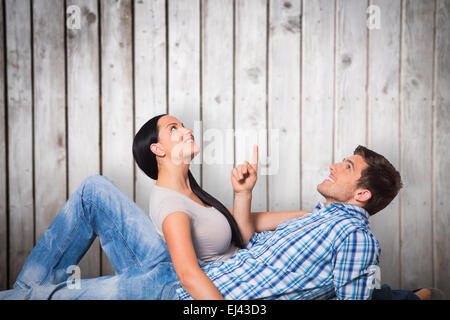 Composite image of young couple lying on floor smiling Stock Photo