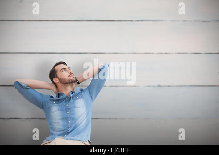 Composite image of handsome man sitting and thinking Stock Photo