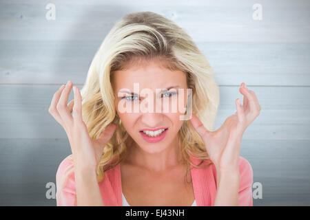 Composite image of pretty young blonde feeling angry Stock Photo