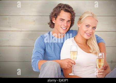 Composite image of couple with glasses of sparkling wine Stock Photo