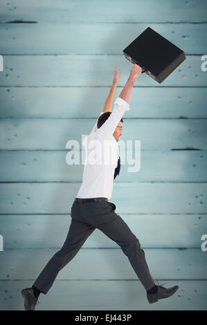 Composite image of businessman leaping with his briefcase Stock Photo