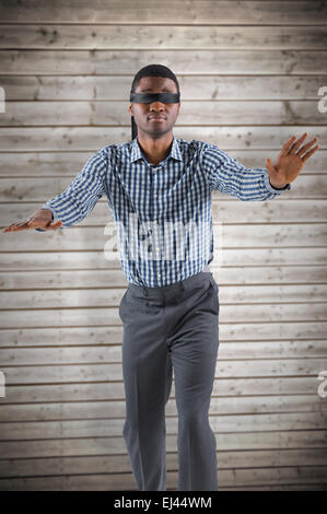 Composite image of blindfolded businessman with arms out Stock Photo