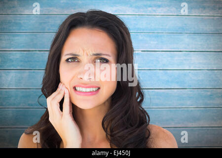 Composite image of pretty brunette with a toothache Stock Photo