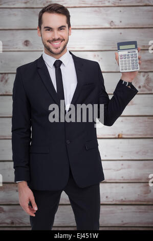 Composite image of smiling businessman presenting a calculator Stock Photo