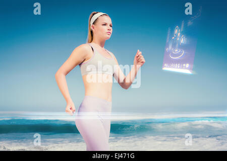 Composite image of sporty focused blonde jogging on the beach Stock Photo