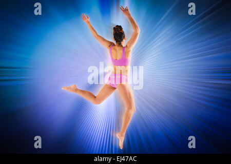 Composite image of fit brunette jumping and posing Stock Photo