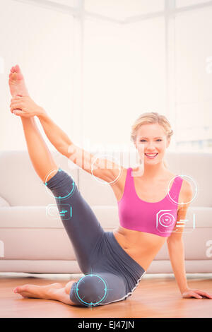Composite image of athletic blonde sitting on floor stretching leg up smiling at camera Stock Photo
