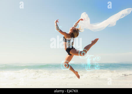 Composite image of fit blonde jumping gracefully with scarf on the beach Stock Photo