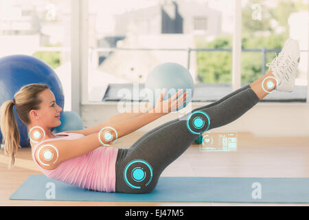 Composite image of sporty young woman stretching body in fitness studio Stock Photo