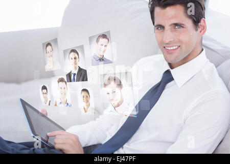 Composite image of smiling businessman using digital tablet Stock Photo