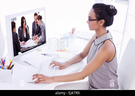 Composite image of designer working at her desk using computer Stock Photo
