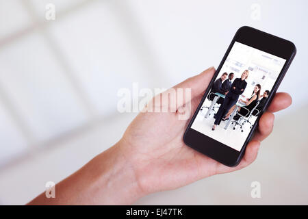 Composite image of womans hand holding black smartphone Stock Photo