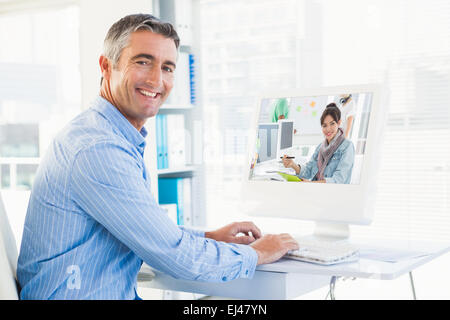 Composite image of artist drawing something on graphic tablet with colleagues behind Stock Photo
