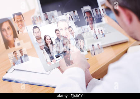 Composite image of doctors using laptop and digital tablet in meeting Stock Photo
