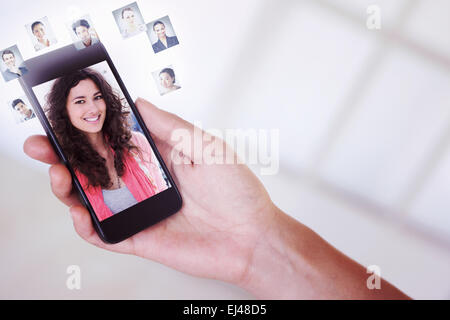 Composite image of womans hand holding black smartphone Stock Photo