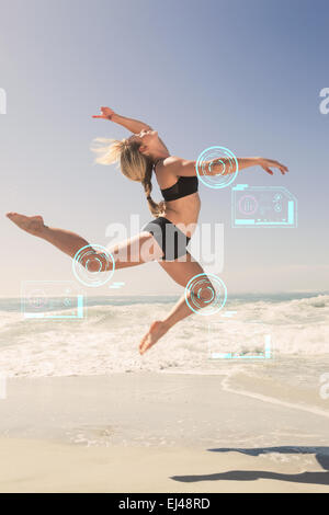 Composite image of fit blonde jumping gracefully on the beach Stock Photo