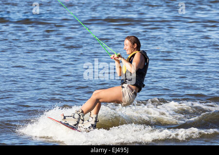 Woman study riding on a wakeboard outdoors Stock Photo