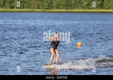 Young woman study riding wake board on a lake Stock Photo