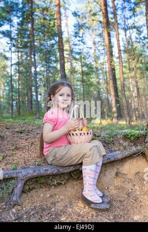 Little girl pick up mushrooms in the forest Stock Photo