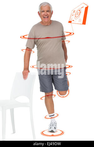 Composite image of full length portrait of a happy senior man stretching leg Stock Photo