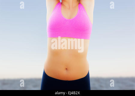 Composite image of smiling toned woman stretching hands on beach Stock Photo