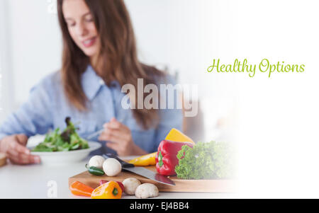 Healthy options against pretty woman eating a vegetarian salad Stock Photo