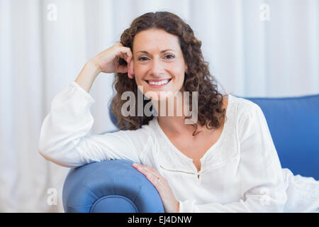 Smiling woman sitting on the couch Stock Photo