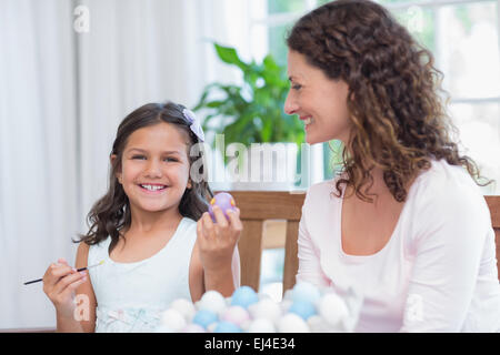 Happy mother and daughter painting easter eggs Stock Photo